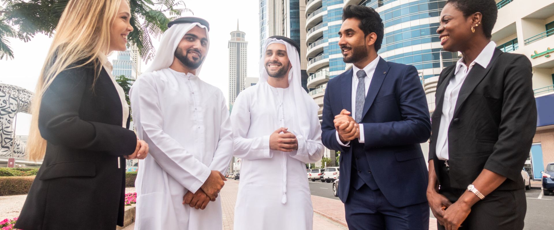 Multi-ethnic group of people on a business meeting in the UAE - Business people walking outdoors and talking about business